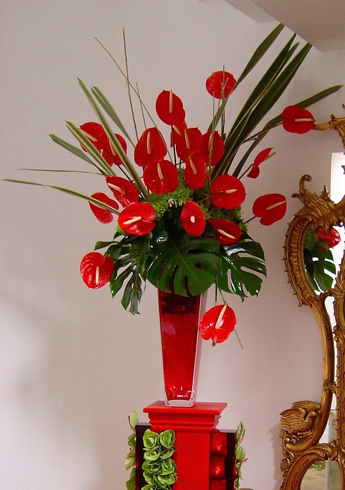 Tall event arrangement with red and green flowers