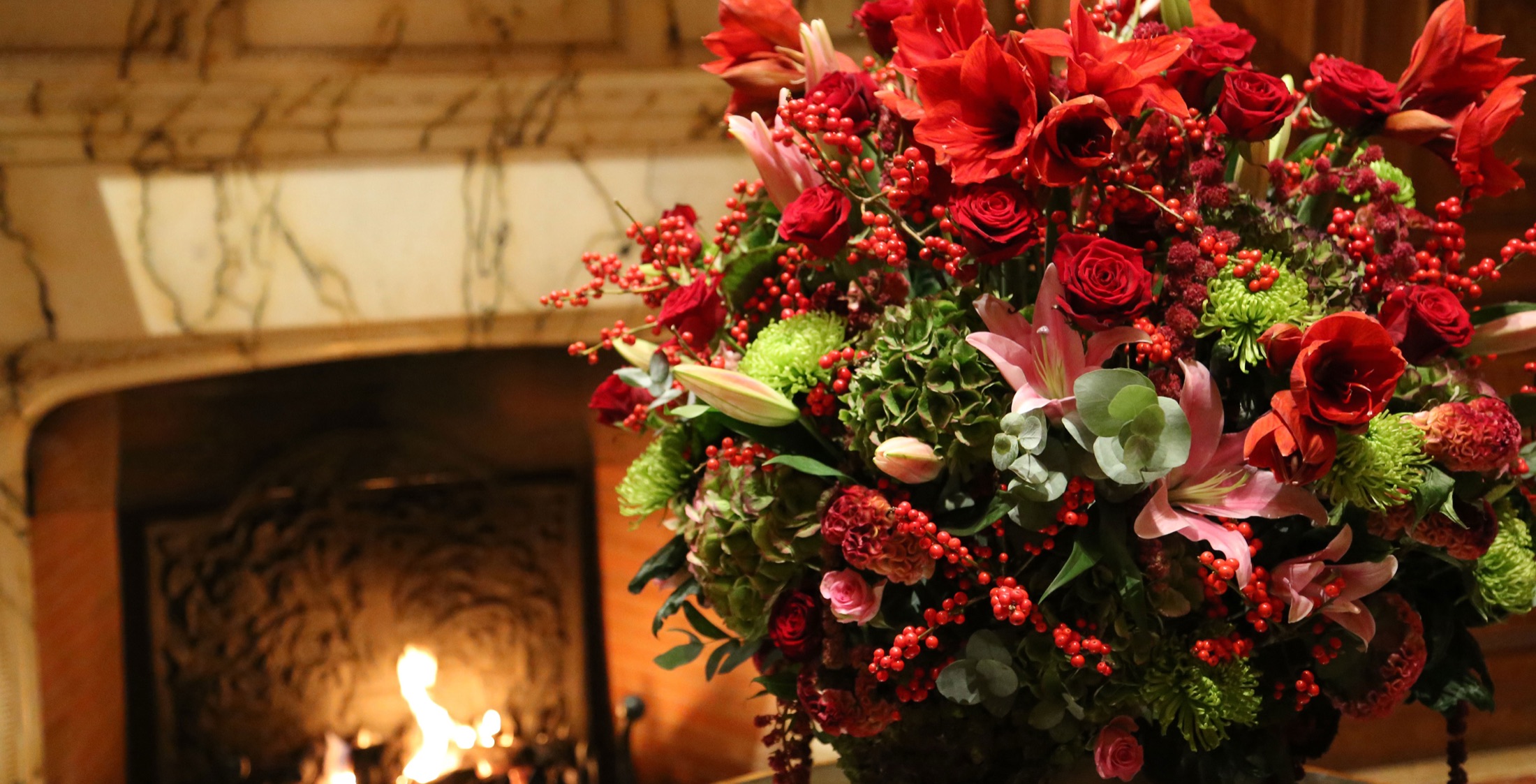 Red roses, lilies, berries, and green hydrangea in a dramatic Pascal Lavorel floral arrangement