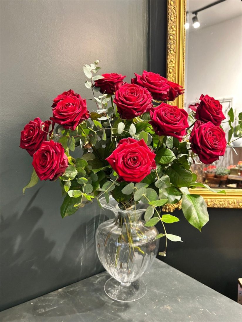 A dozen red roses hand-tied into a romantic bouquet